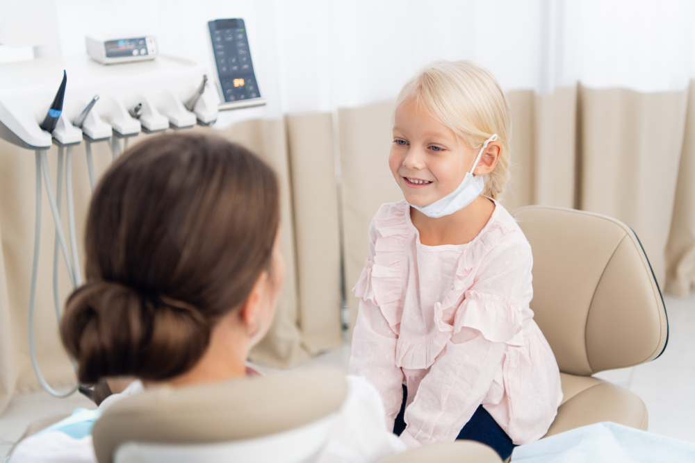 Dentist office. Little girl sitting in the dentistrys office, talking to a pediatric dentist
